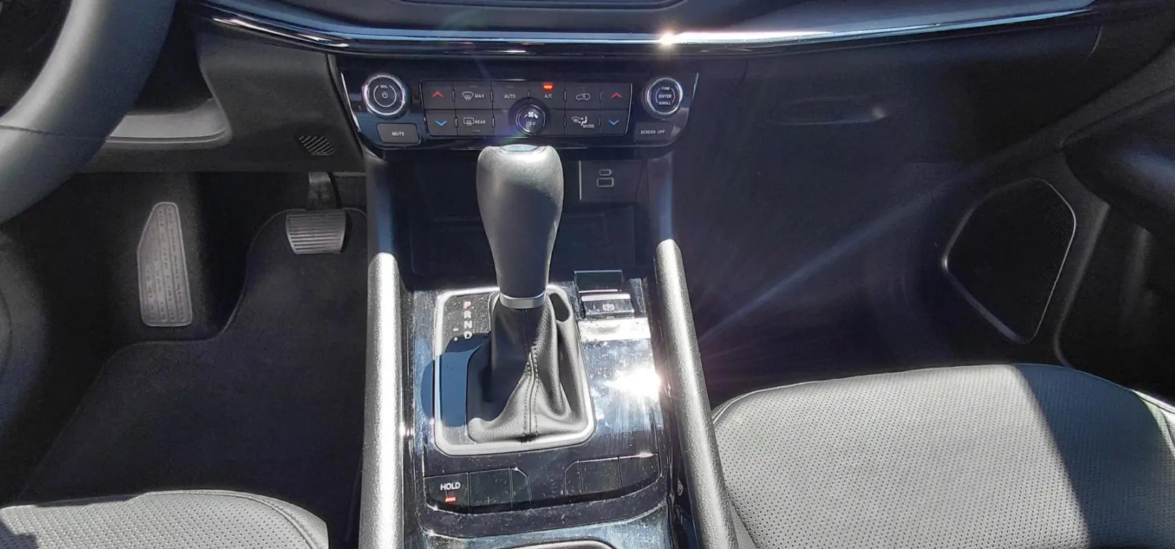 Vue rapprochée de la console centrale noire du Jeep Compass 2025, avec levier de vitesse automatique et commandes climatisation.