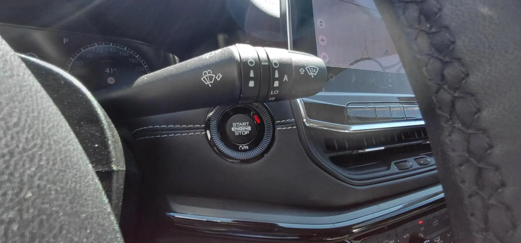 Gros plan intérieur sur le bouton Start Engine Stop et la commande d’essuie-glace du Jeep Compass 2025 noir.