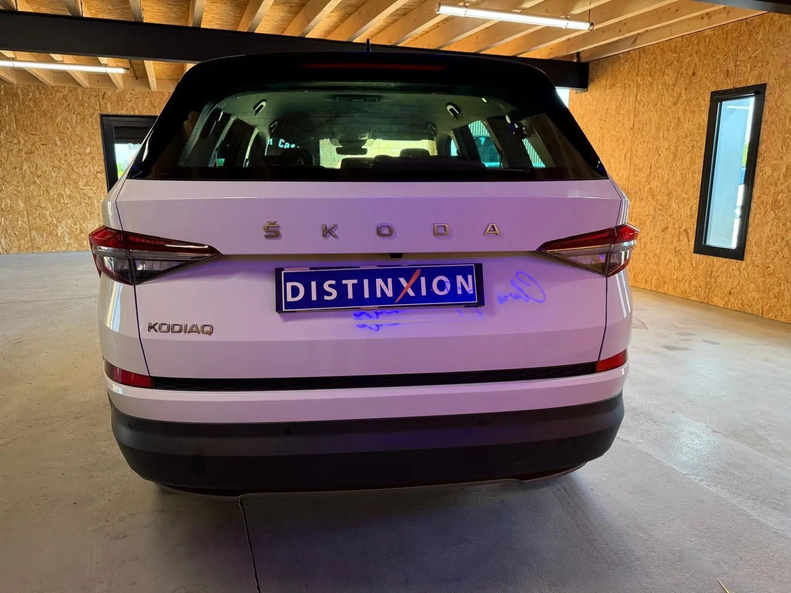 Vue intérieure côté gauche des sièges arrière en tissu noir du Skoda Kodiaq blanc 2023, avec appuie-têtes et aérateurs centraux.