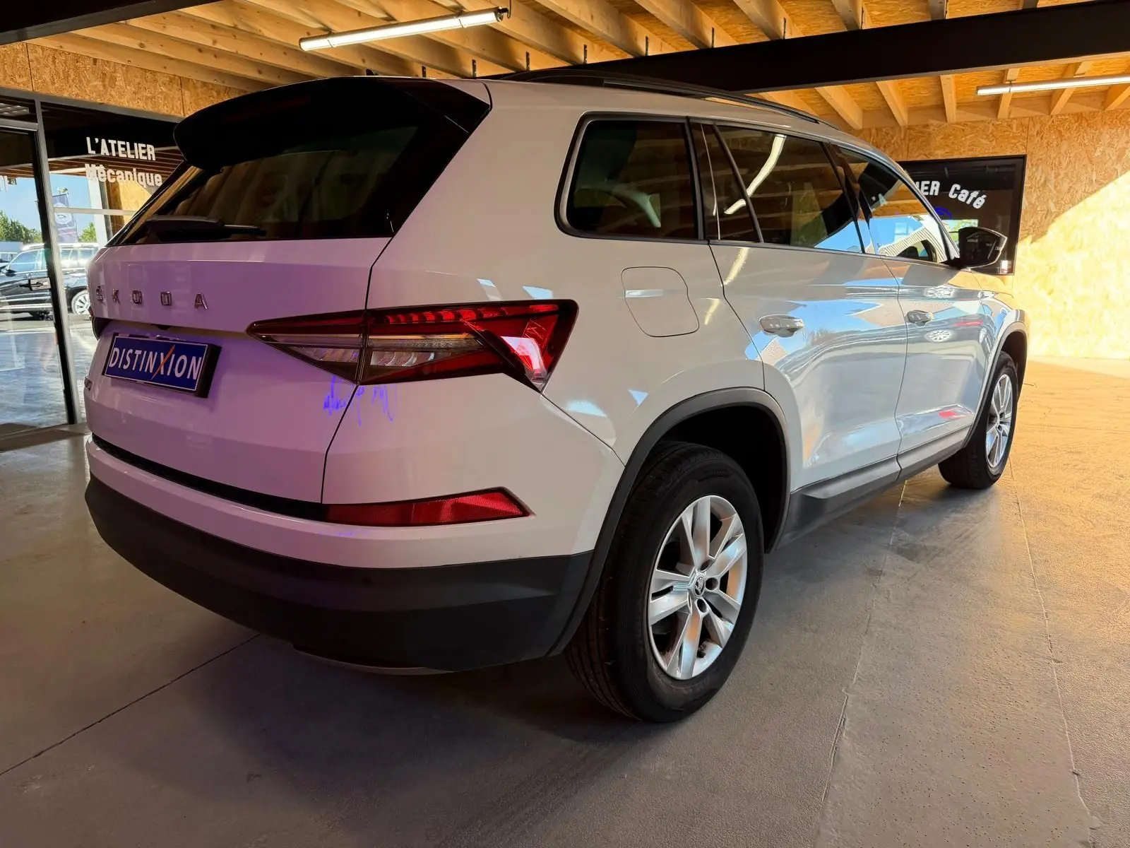 Coffre ouvert d'un Skoda Kodiaq blanc 2023, vue arrière montrant les sièges arrière relevés et l'espace de chargement.