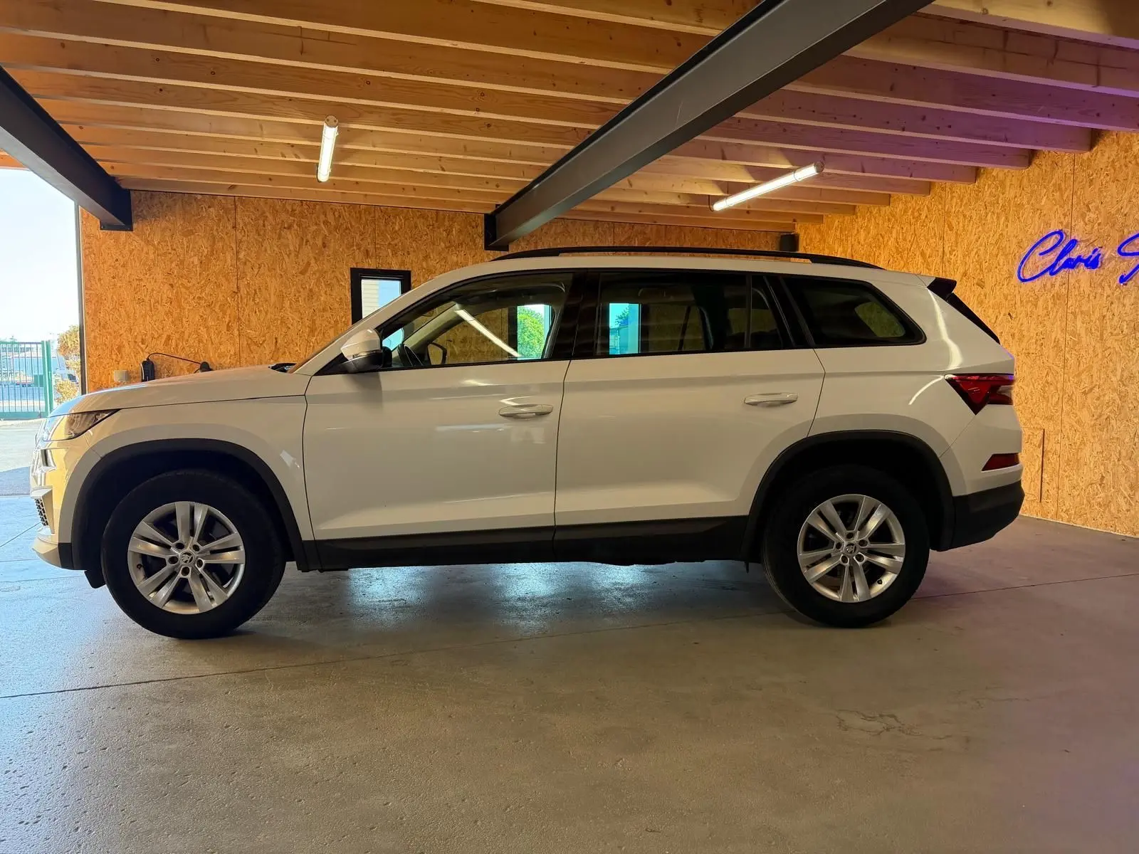 Vue intérieure du tableau de bord noir du Skoda Kodiaq 2023, avec écran tactile central et commandes de climatisation.
