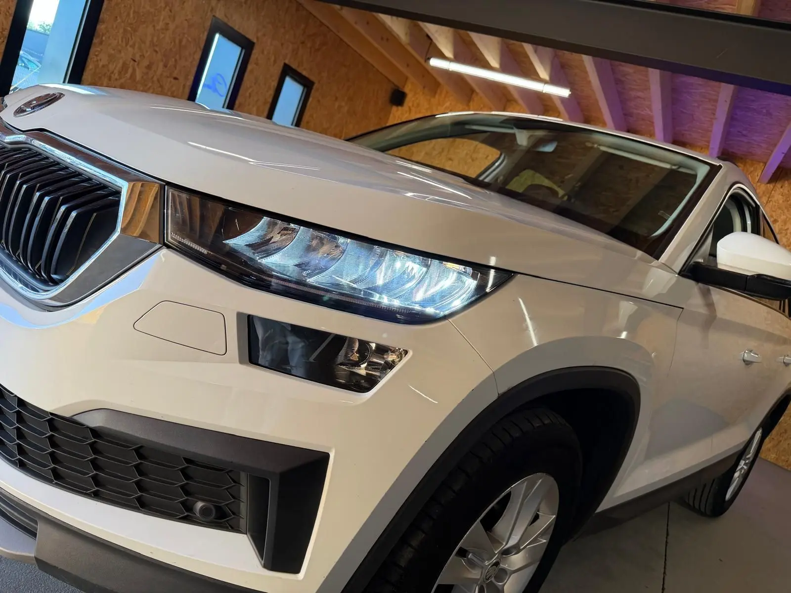 Vue du coffre du Skoda Kodiaq blanc 2023 montrant la roue de secours temporaire et les outils de changement de pneu.