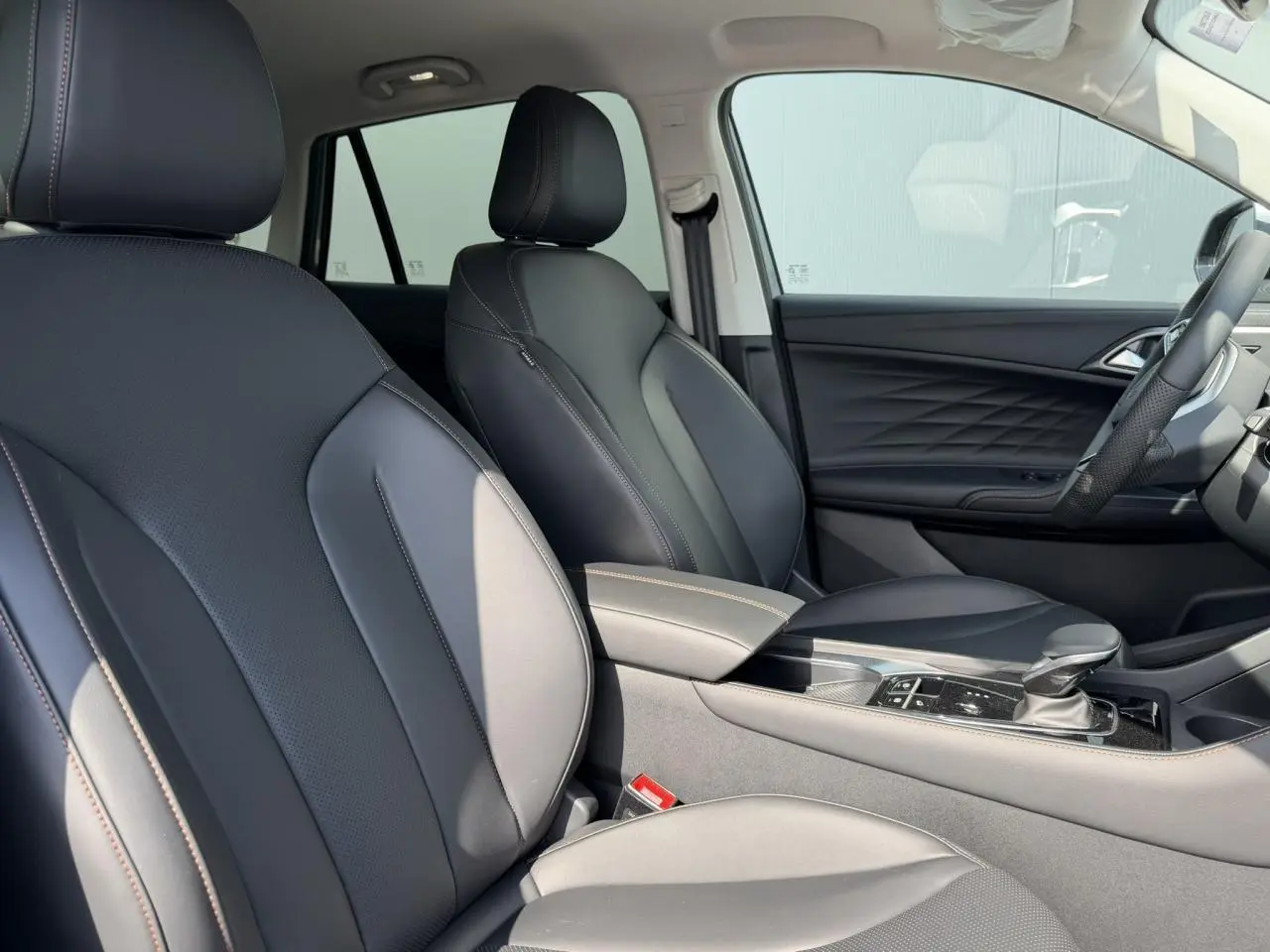 Intérieur noir du MG Motor EHS 1.5 Hybrid+ 224 Luxury vu côté droit, avec sièges simili cuir et accoudoir central.