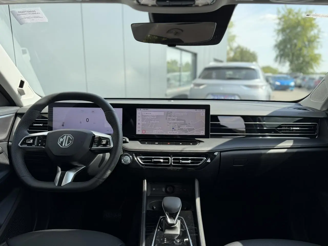 Vue intérieure avant du MG Motor EHS gris, mettant en valeur le tableau de bord numérique et l'écran tactile panoramique.