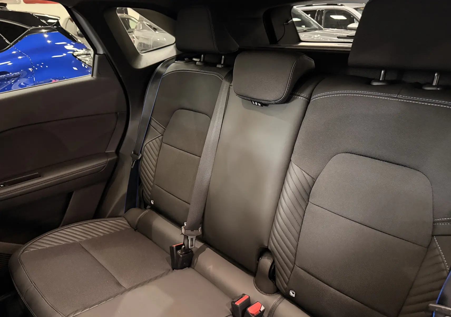 Vue intérieure sur les sièges arrière noirs avec surpiqûres bleues du Renault Symbioz E-Tech full hybrid 2026.