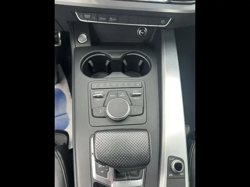 Vue rapprochée de la console centrale de l'Audi A5 Sportback bleu lunaire, avec commandes multimédia et levier de vitesses.