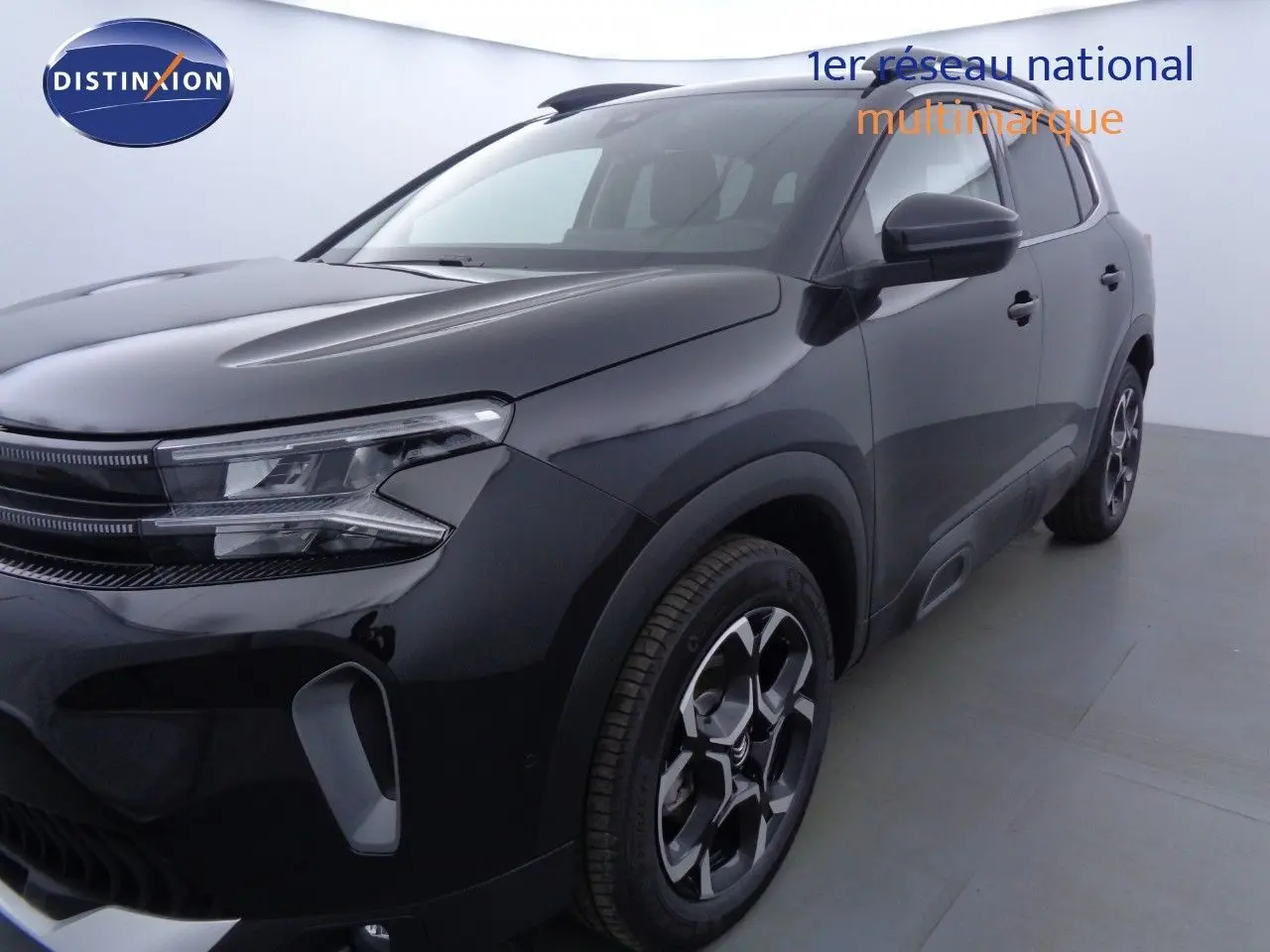 Vue 3/4 avant droite d'un Citroën C5 Aircross noir métal avec jantes bi-ton et phares LED distinctifs.