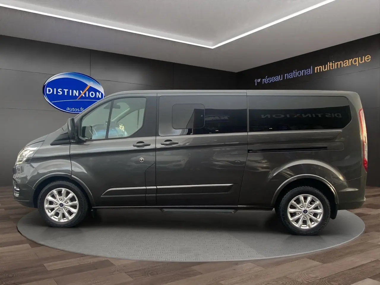Vue latérale droite d'un Ford Tourneo Custom gris Magnetic 2020 avec vitres teintées et jantes alliage.