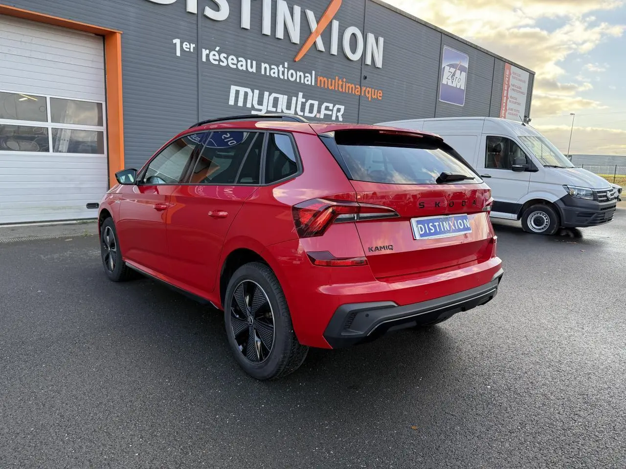 Vue 3/4 arrière droite d'un SKODA KAMIQ Monte-Carlo rouge velvet métallisé avec jantes noires et vitres surteintées.