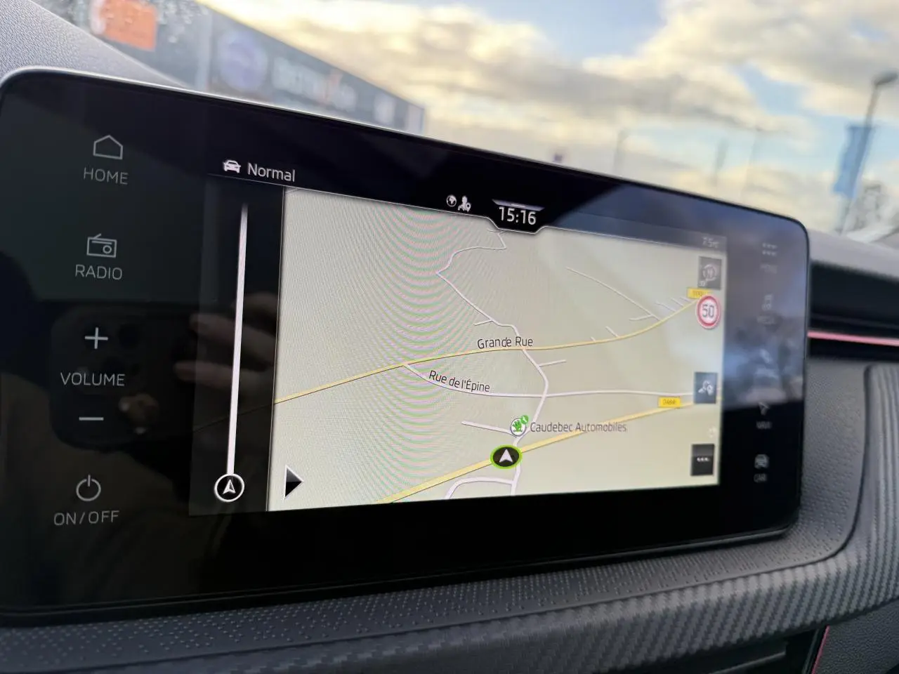 Vue rapprochée de l’écran tactile central du Skoda Kamiq rouge Velvet, affichant la navigation GPS en extérieur.