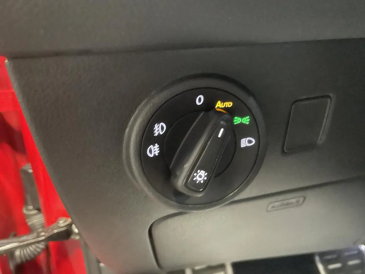Gros plan sur le sélecteur de phares intérieur du SEAT Ateca rouge 2022, version 2.0 TDI FR avec boîte auto.