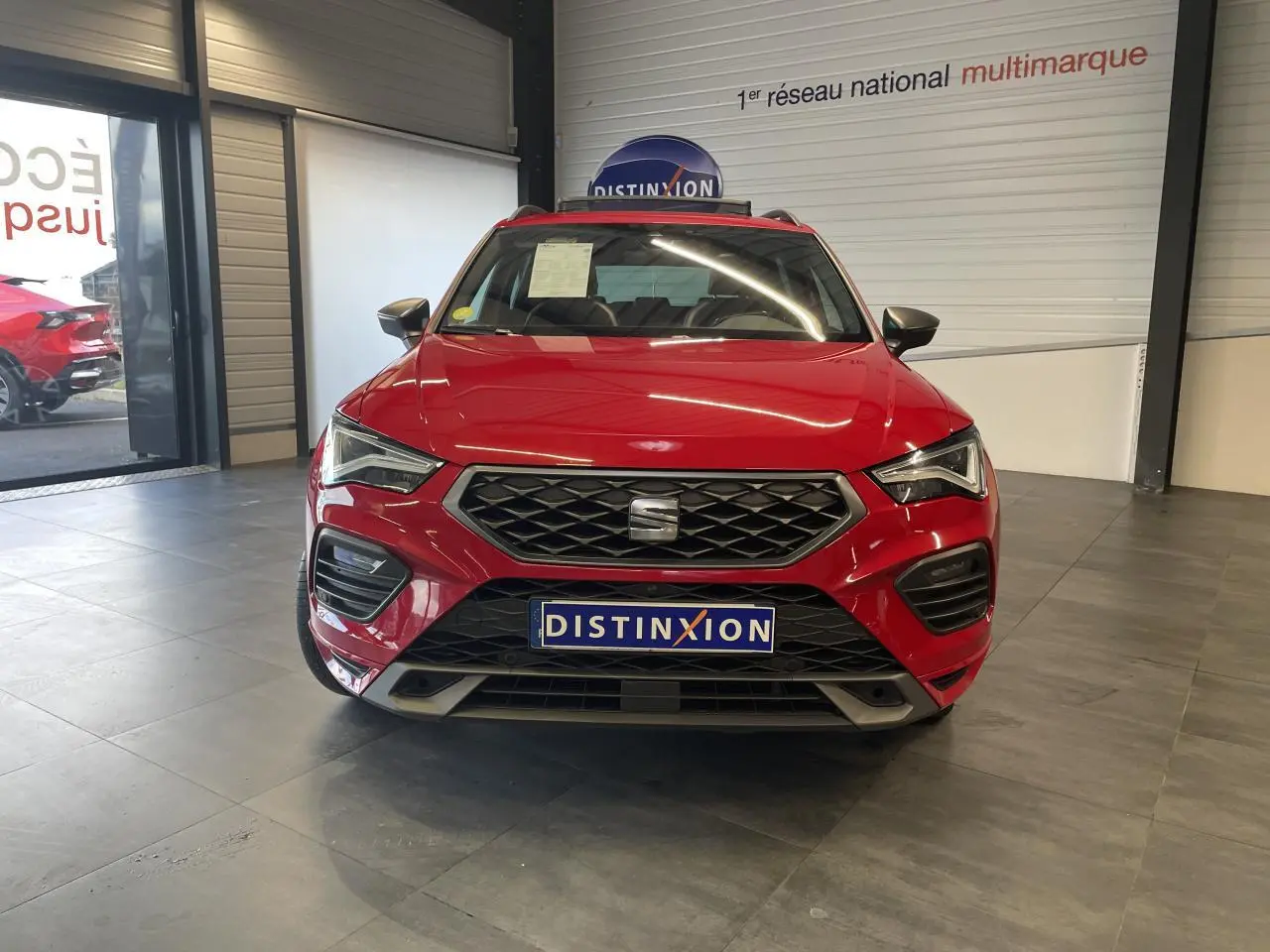 Vue frontale d'un SEAT Ateca rouge 2022 version 2.0 TDI FR, avec calandre noire et plaque Distinxion visible.