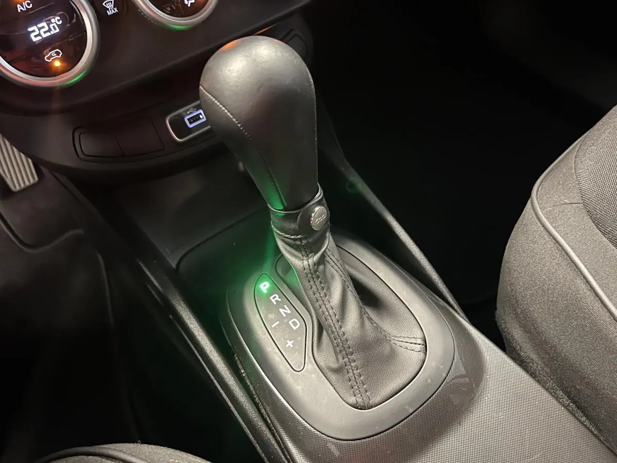 Le levier de vitesses automatique noir de la Fiat 500X 2024 vu en gros plan côté droit, avec indication verte sur la position P.