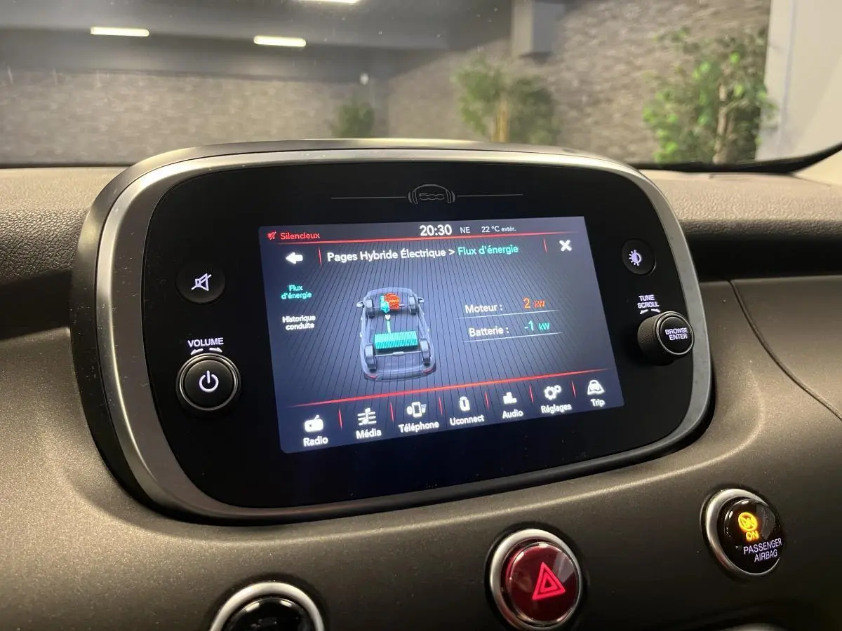 Écran tactile central du tableau de bord de la Fiat 500X 2024 montrant le flux d'énergie hybride.