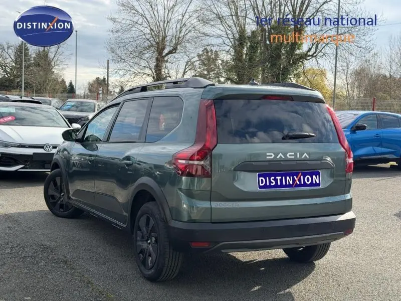 Vue 3/4 arrière droite du Dacia Jogger 2025 Vert Cèdre métallisé, version 7 places avec barres de toit noires.