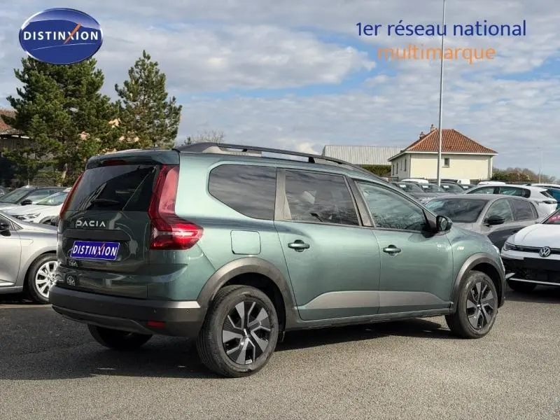 Vue 3/4 arrière droite du Dacia Jogger 2025 Vert Cèdre métallisé, version 7 places avec détails noirs et jantes spécifiques.