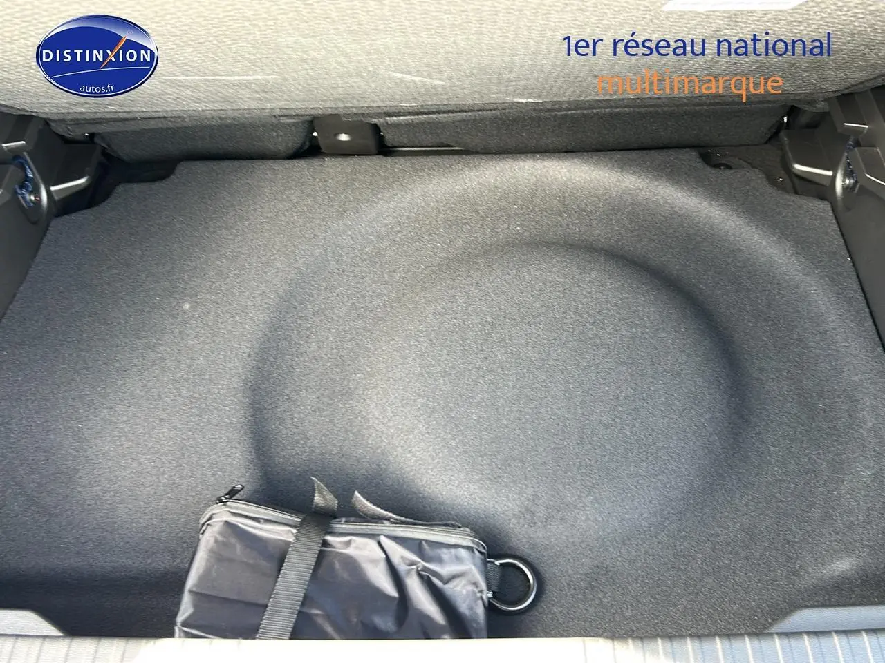 Coffre ouvert du Renault Captur noir Étoile, vue plongeante sur le rangement sous plancher avec trousse noire.