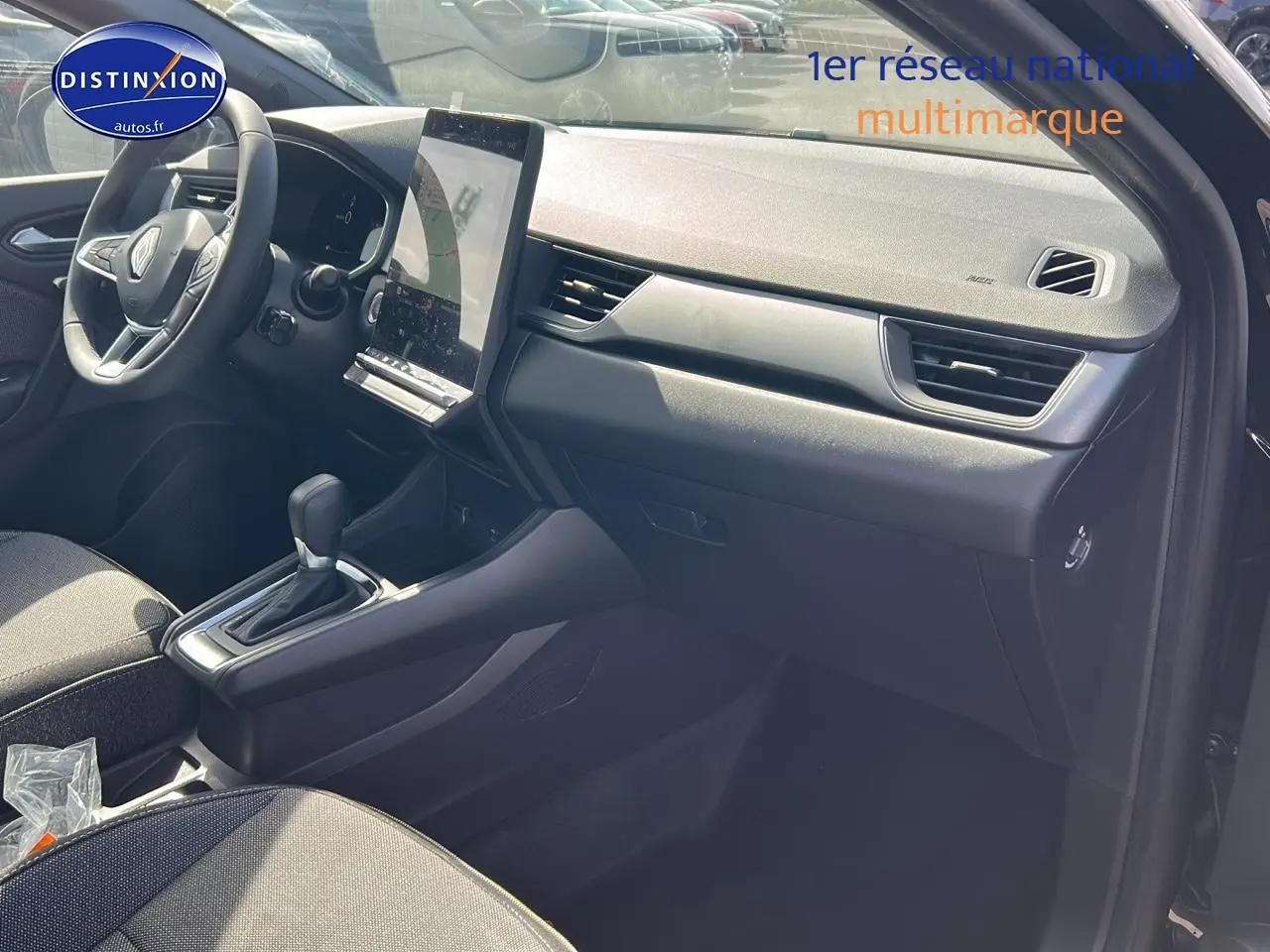 Intérieur avant droit du Renault Captur noir étoile 2025, avec tableau de bord moderne et écran tactile vertical.