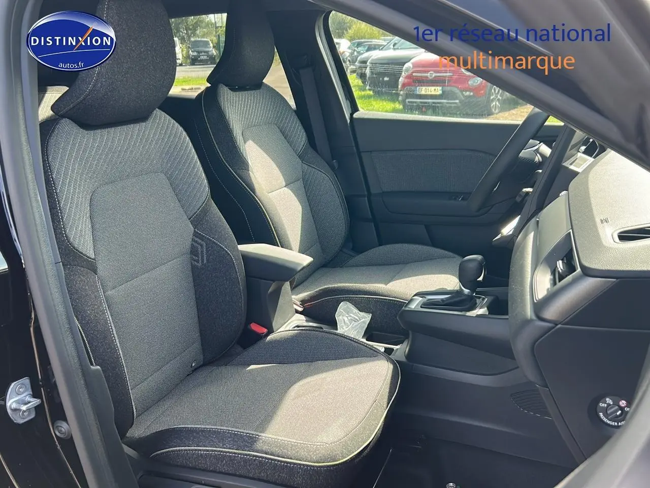 Vue intérieure côté conducteur du Renault Captur 1.6 e-tech hybride 2025, sièges tissu gris et console centrale noire.