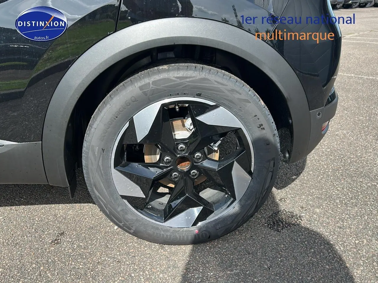 Gros plan sur la roue arrière droite du Renault Captur noir Étoile avec jante alu au design étoilé.