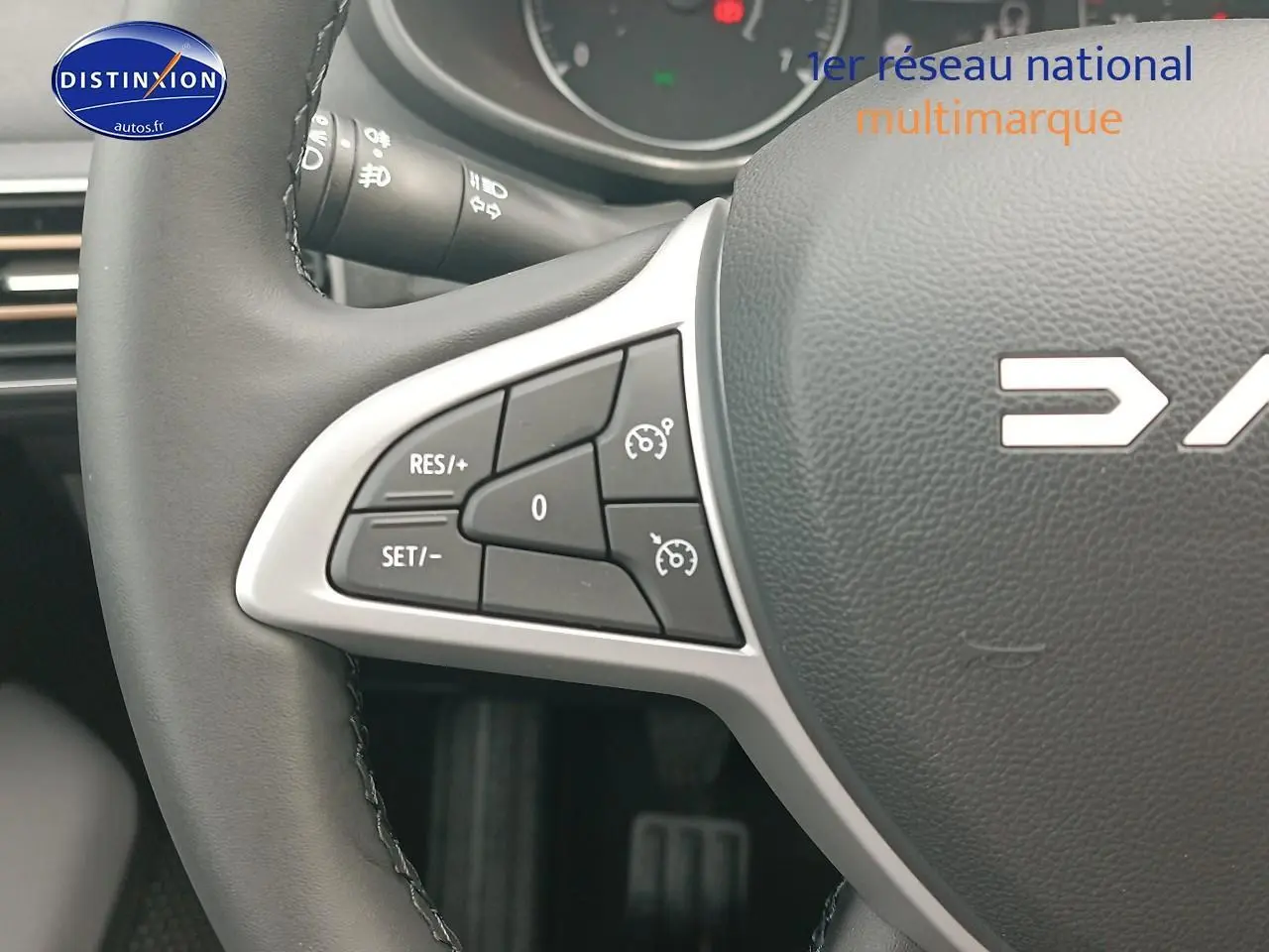 Gros plan sur le volant noir de la Dacia Sandero 2025, avec commandes de régulateur de vitesse côté gauche.