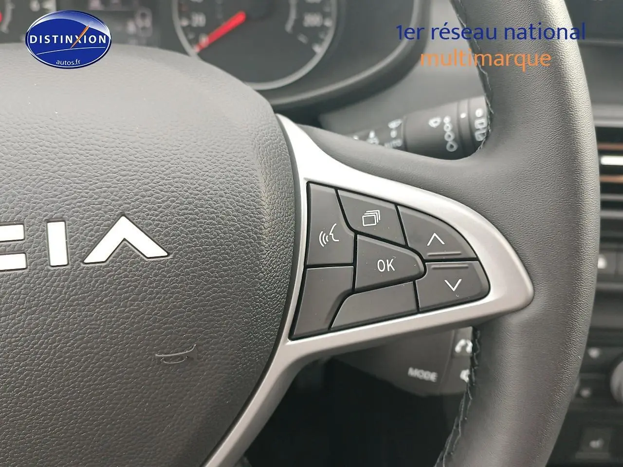 Gros plan sur les commandes multifonctions du volant noir de la Dacia Sandero 2025, côté droit.