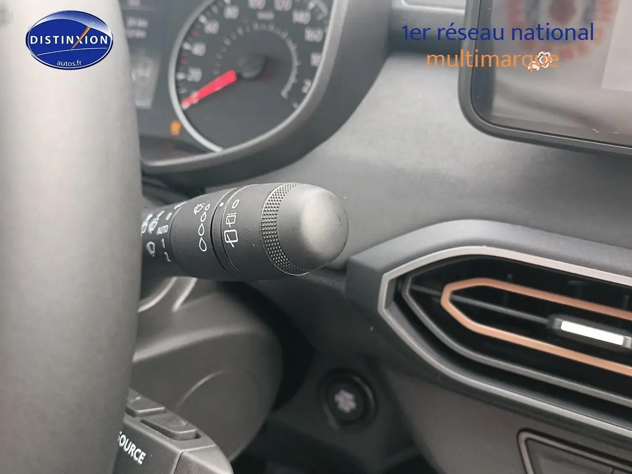 Gros plan sur la commande d’essuie-glace à gauche du volant dans l’habitacle noir du Dacia Sandero 2025.