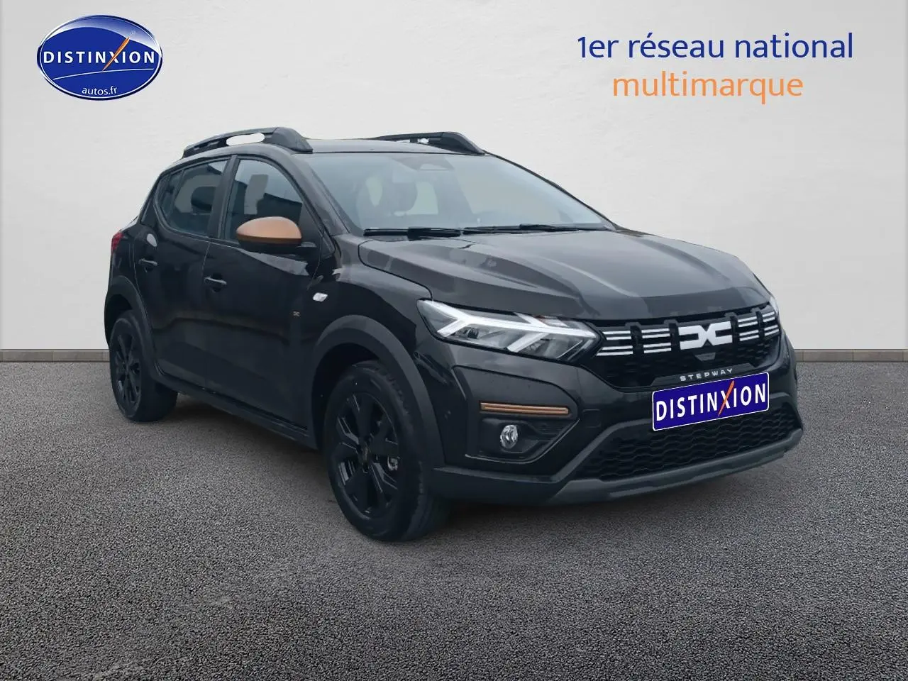 Vue 3/4 avant d'une Dacia Sandero Stepway noire avec rétroviseurs marron et jantes noires sur fond neutre.
