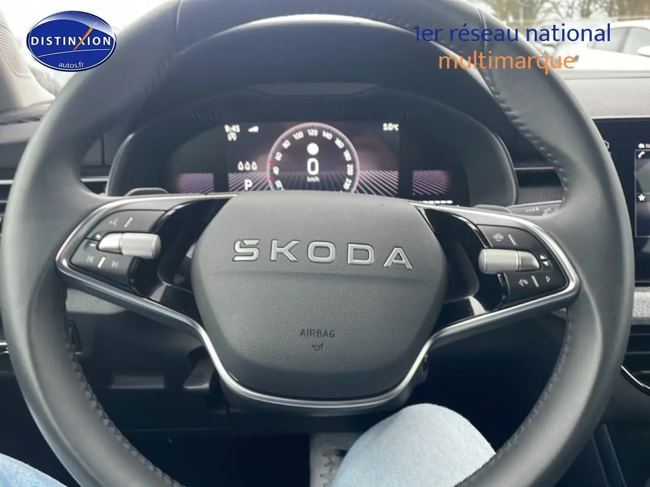 Vue rapprochée du volant cuir multifonction SKODA noir avec logo central et commandes intégrées.