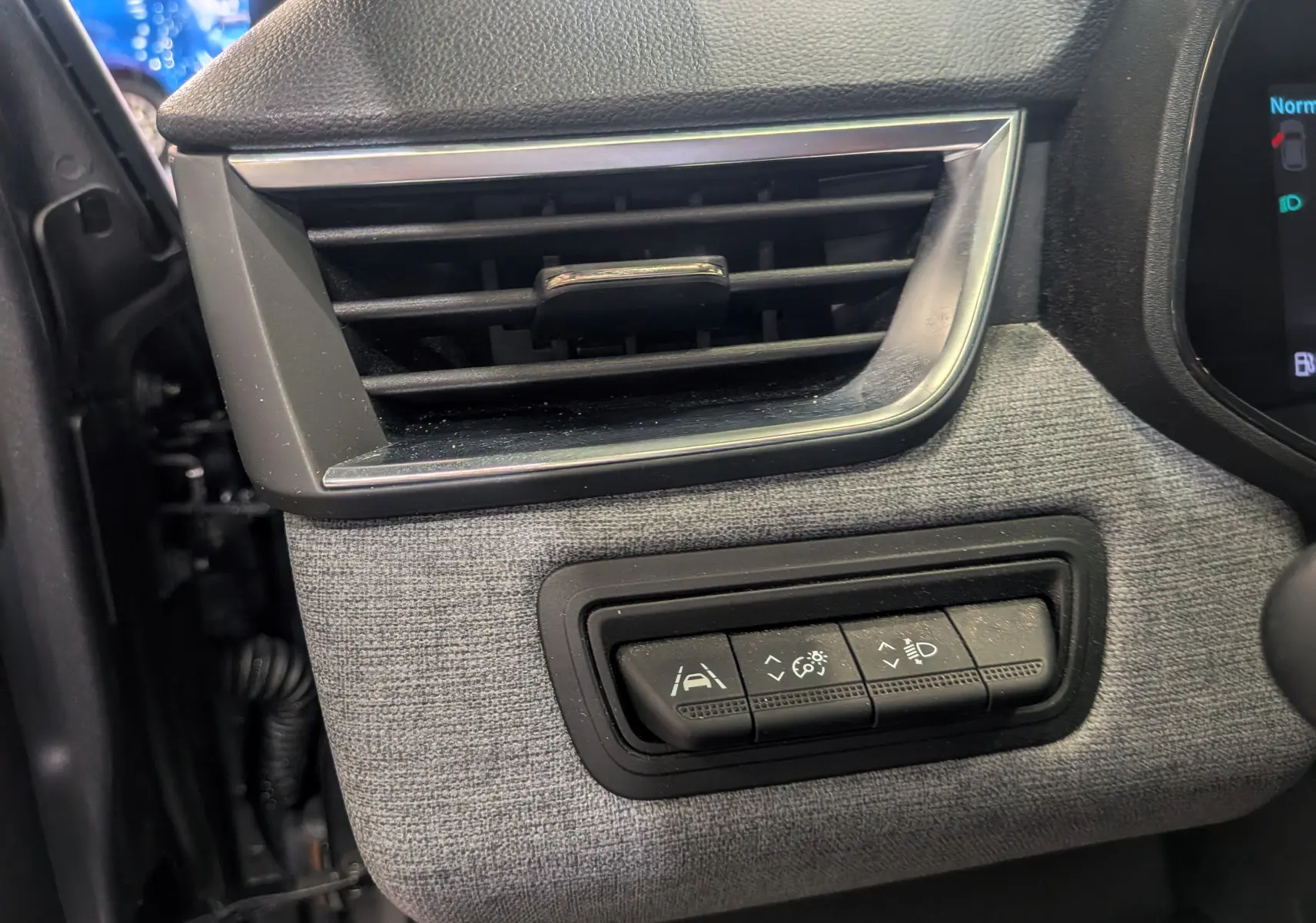 Détail du tableau de bord de la Renault Clio V TCe 90 Evolution 2024, montrant les commandes d'assistance et la sortie d'air.