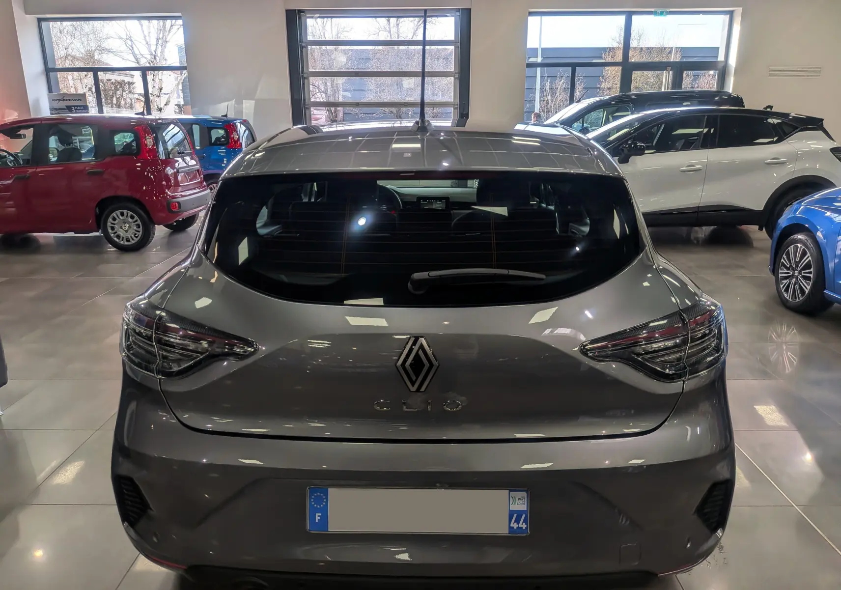Vue arrière d'une Renault Clio V TCe 90 Gris Schiste 2024, avec feux arrière LED et logo Renault bien visible.
