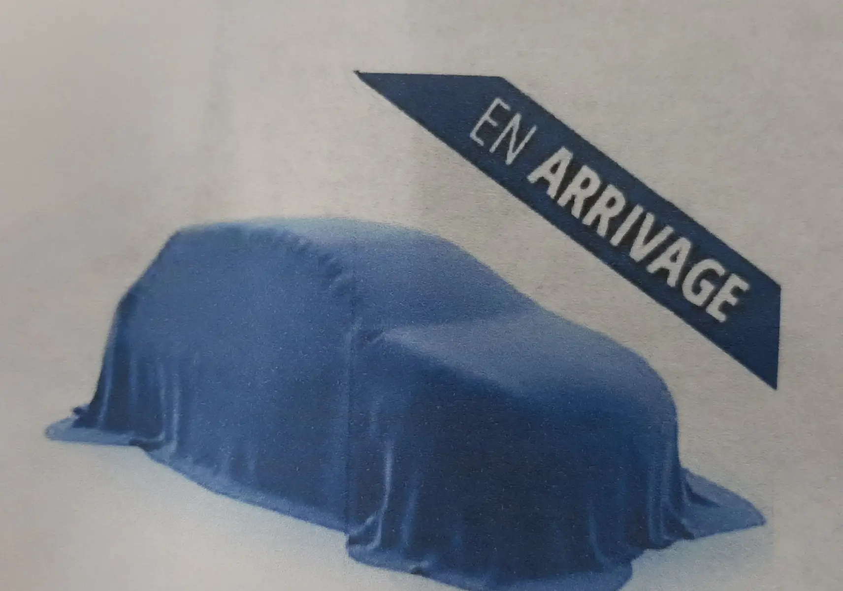 Voiture couverte d'une housse bleue, vue de profil gauche, avec un bandeau indiquant "En arrivée".
