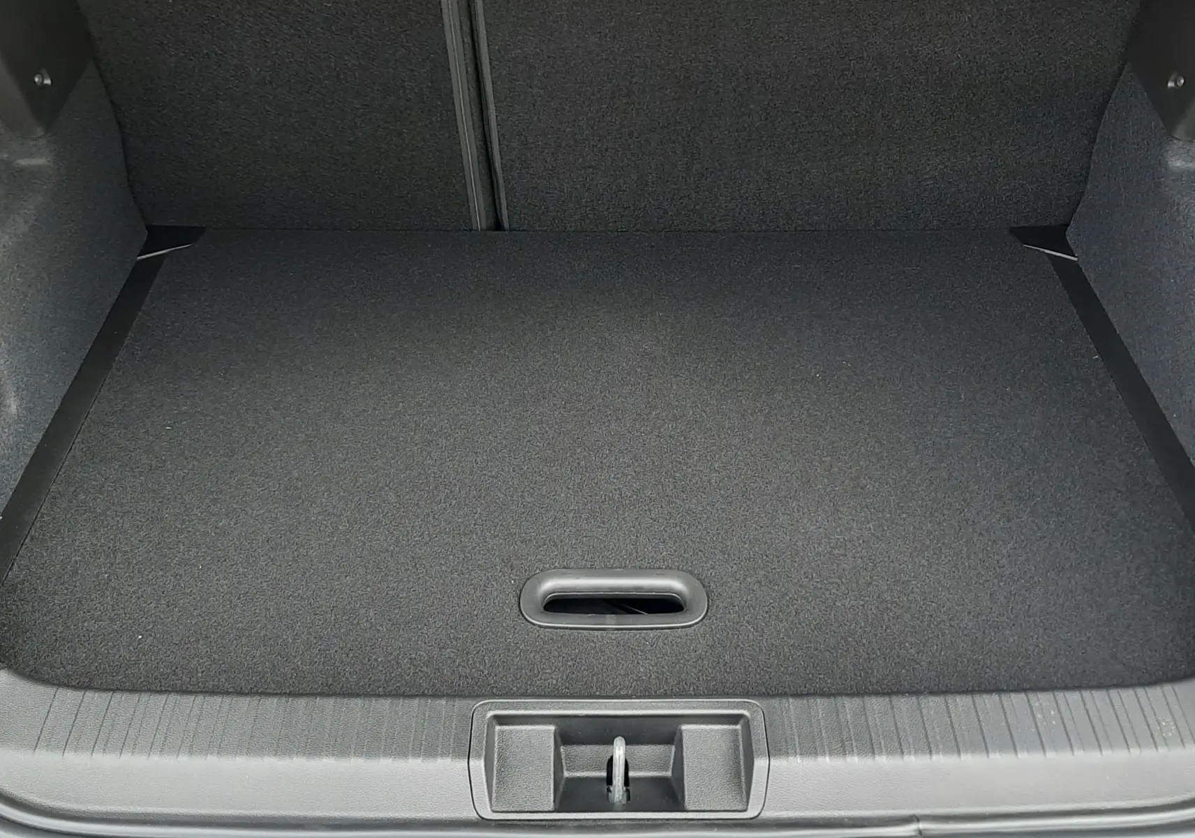 Coffre ouvert vu de l'arrière d'un Renault Captur E-Tech Full Hybrid gris Cassiopée avec toit noir, intérieur noir.