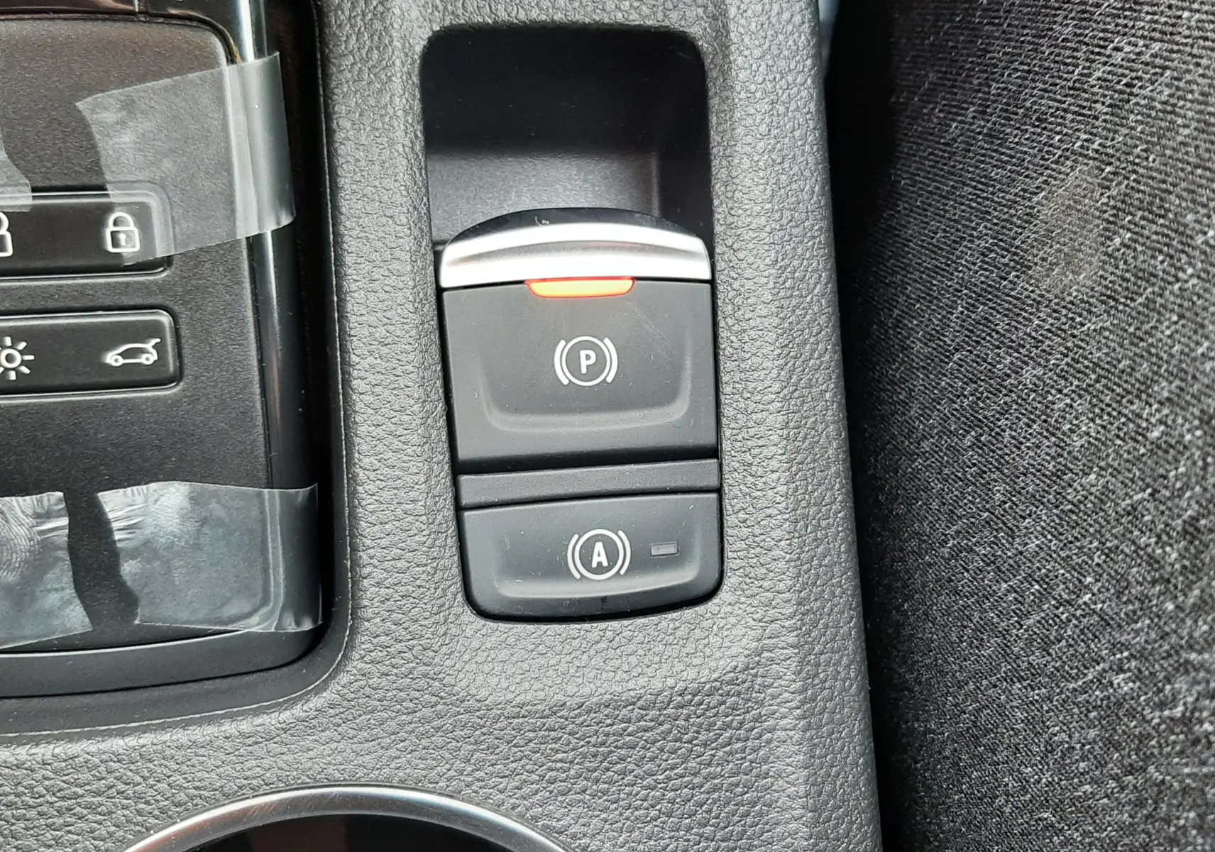 Gros plan sur les commandes de frein à main électronique et arrêt automatique du moteur du Renault Captur E-Tech gris cassiopée.