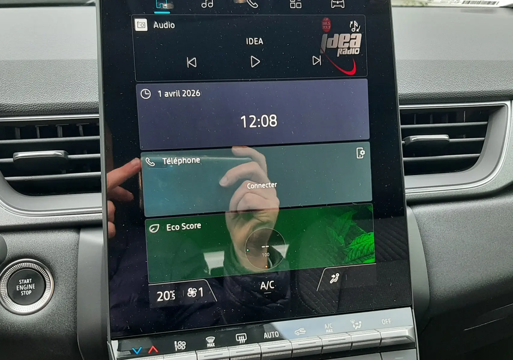 Vue rapprochée de l’écran tactile central du Renault Captur E-Tech 2026, avec commandes climatisation et bouton start/stop visibles.