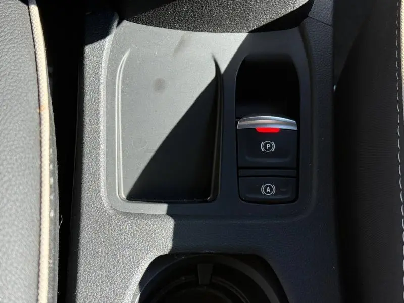 Gros plan sur la console centrale de la Renault Clio 2025, montrant le frein à main électronique et le bouton auto hold.