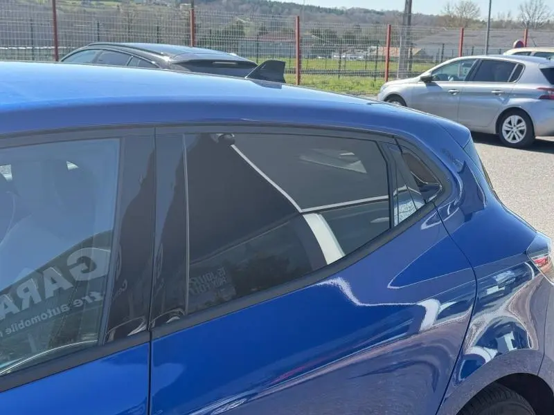 Vue latérale droite sur la partie arrière d’une Renault Clio 2025 Bleu Iron avec vitres teintées et antenne requin.