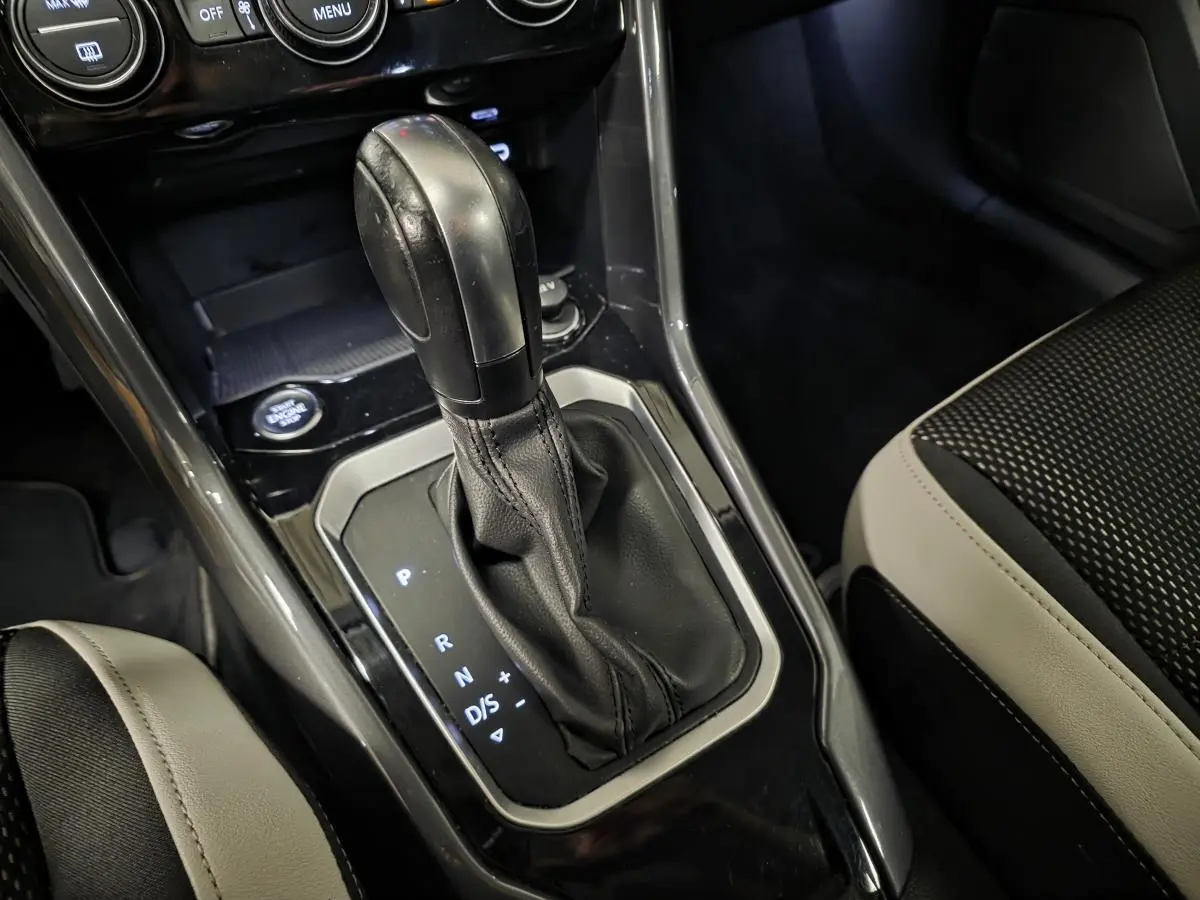 Gros plan sur la console centrale du Volkswagen T-Roc 2.0 TDI 2021, montrant le levier de vitesses automatique en cuir noir.