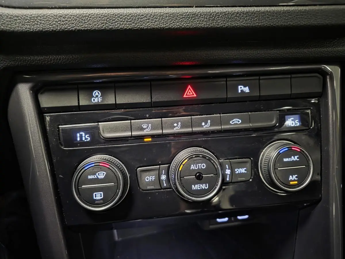 Gros plan sur la console centrale du Volkswagen T-Roc 2021, montrant les commandes de climatisation automatique bi-zone.