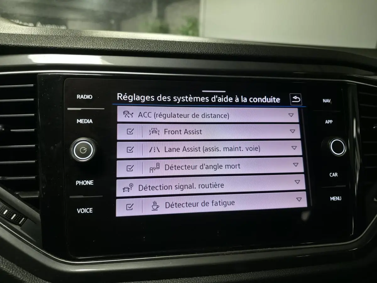 Écran tactile intérieur du Volkswagen T-Roc montrant les réglages des aides à la conduite.