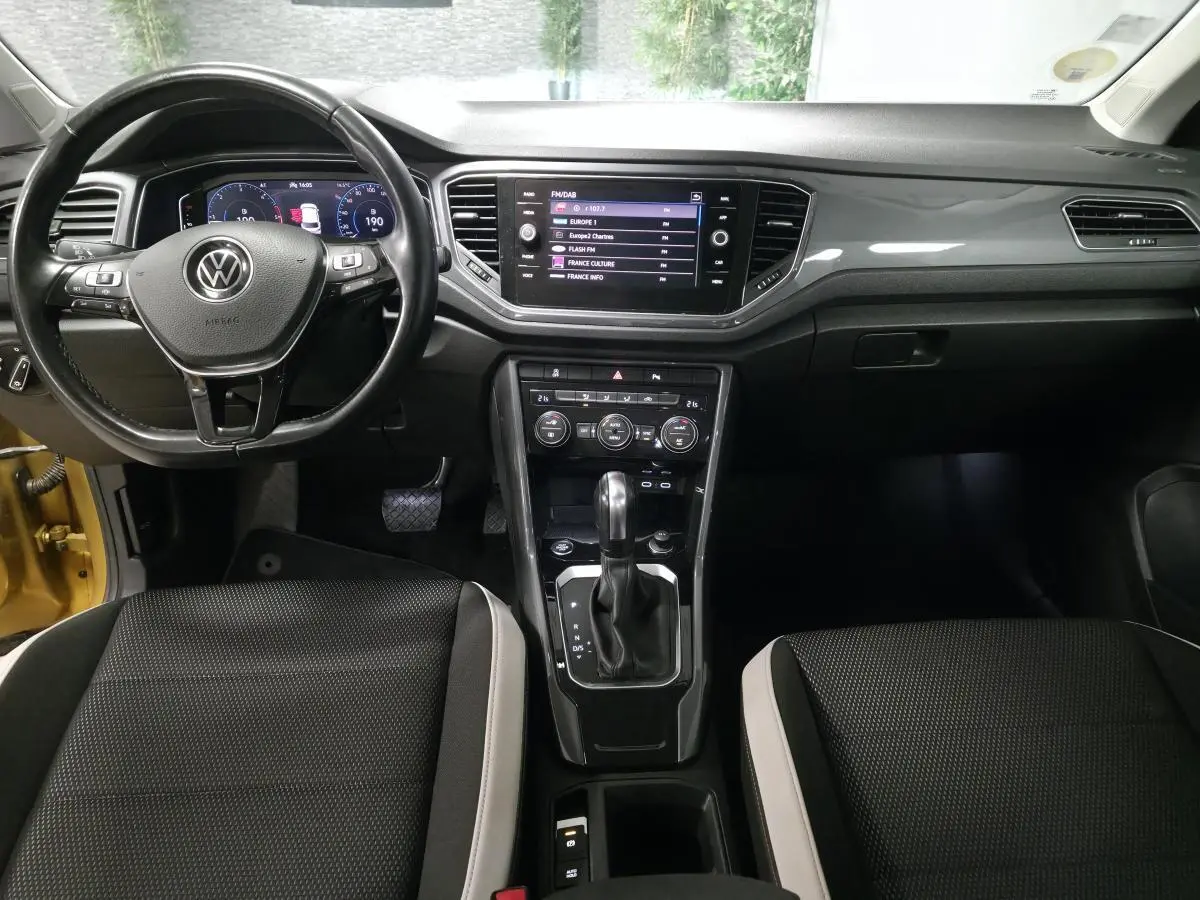 Vue intérieure avant du Volkswagen T-Roc 2.0 TDI 2021, tableau de bord noir avec écran tactile et volant multifonction.