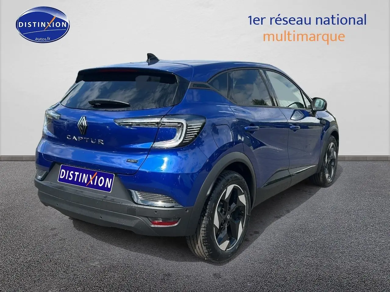 Vue 3/4 arrière droite d'un Renault Captur 2025 bleu iron avec jantes alu et vitres teintées.