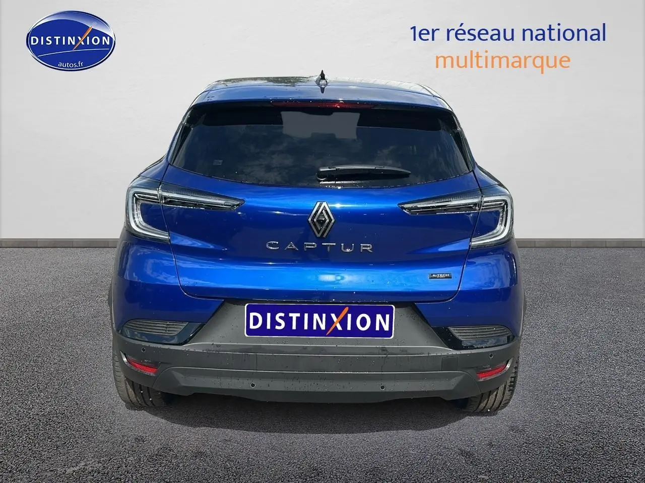 Vue arrière du Renault Captur 1.6 e-tech hybride 145 techno en bleu iron avec feux arrière LED et lunette arrière surteintée.