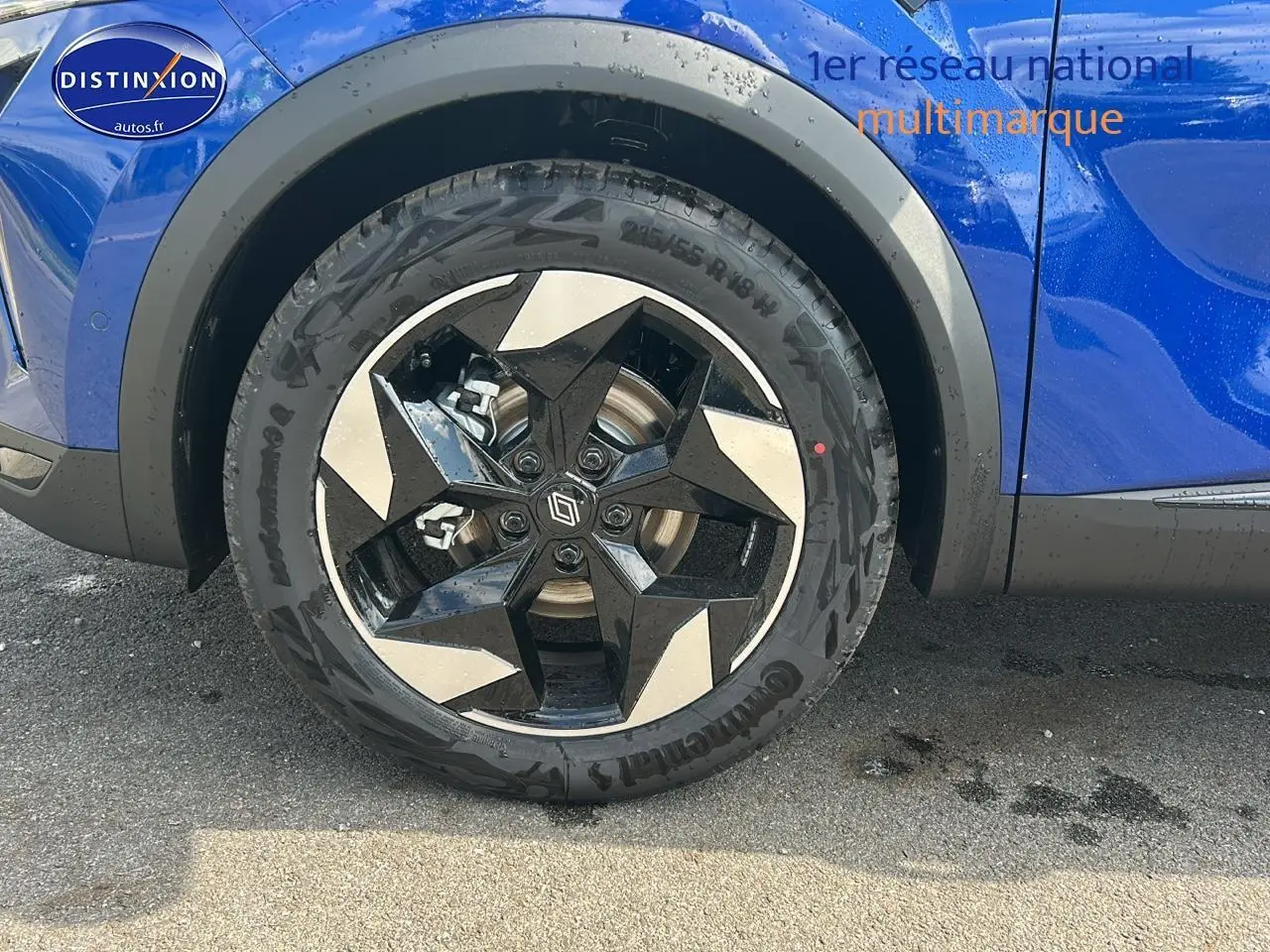 Gros plan sur la roue avant droite du Renault Captur bleu iron avec jante alu au design géométrique.