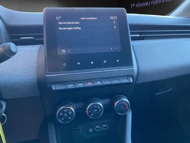 Vue rapprochée du tableau de bord central gris foncé de la Renault Clio Evolution 2024 avec écran tactile et commandes climatisation.