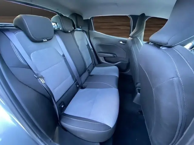 Vue intérieure arrière de la banquette trois places de la Renault Clio Evolution TCe 90 2024, sièges gris foncé avec ceinture de sécurité.