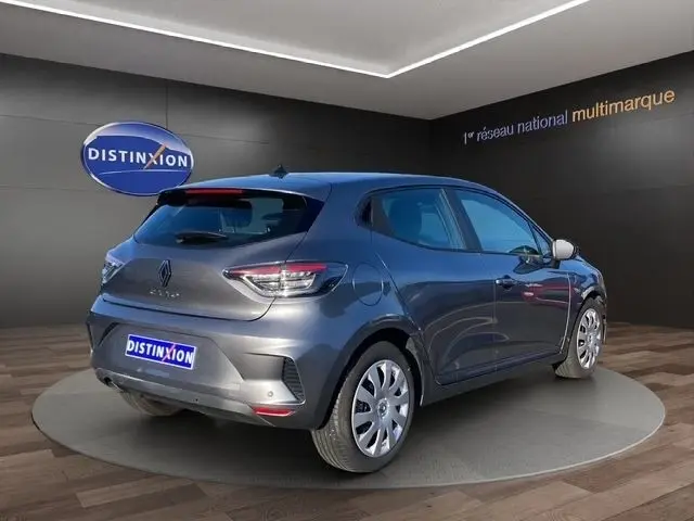 Vue 3/4 arrière droite d'une Renault Clio Evolution TCe 90 gris foncé en showroom avec feux arrière LED visibles.