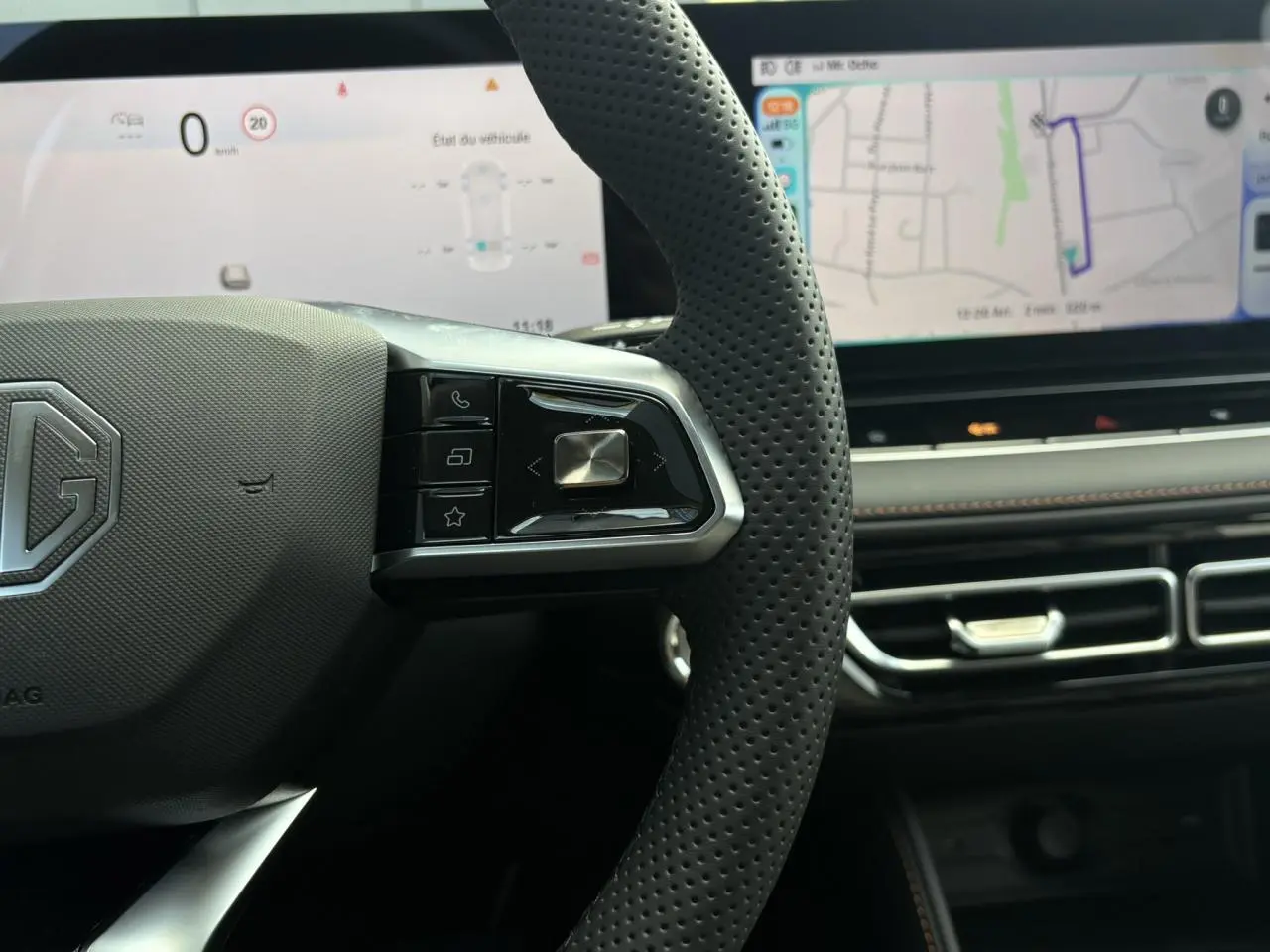 Gros plan sur le volant noir perforé MG EHS 1.5 Hybrid+ 224 Luxury avec tableau de bord numérique et écran tactile large.