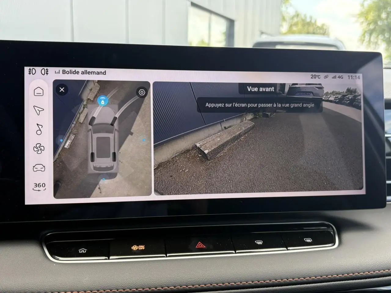 Écran tactile intérieur montrant la caméra 360° et vue avant du sol avec bordure de parking, dans un MG Motor EHS blanc.