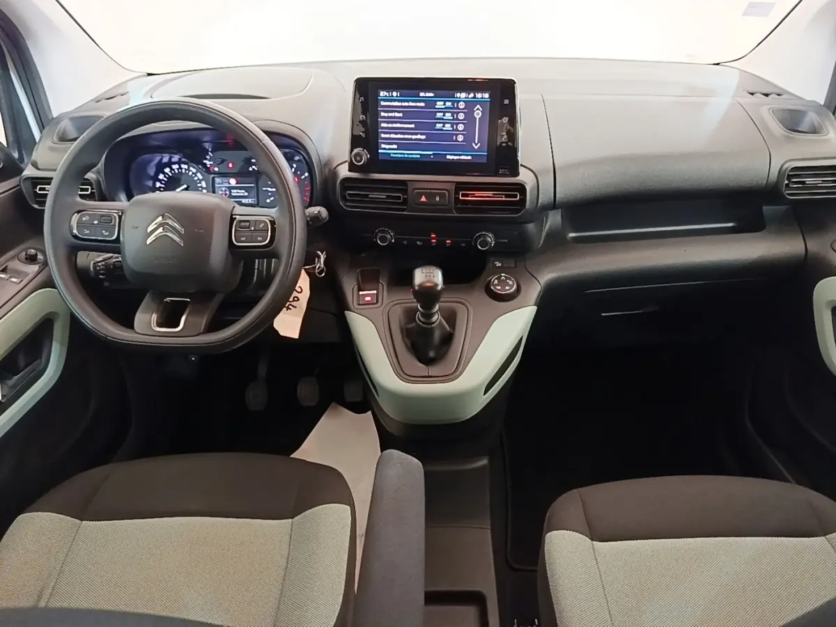 Vue intérieure frontale du tableau de bord du Citroën Berlingo blanc avec écran tactile et volant multifonctions.